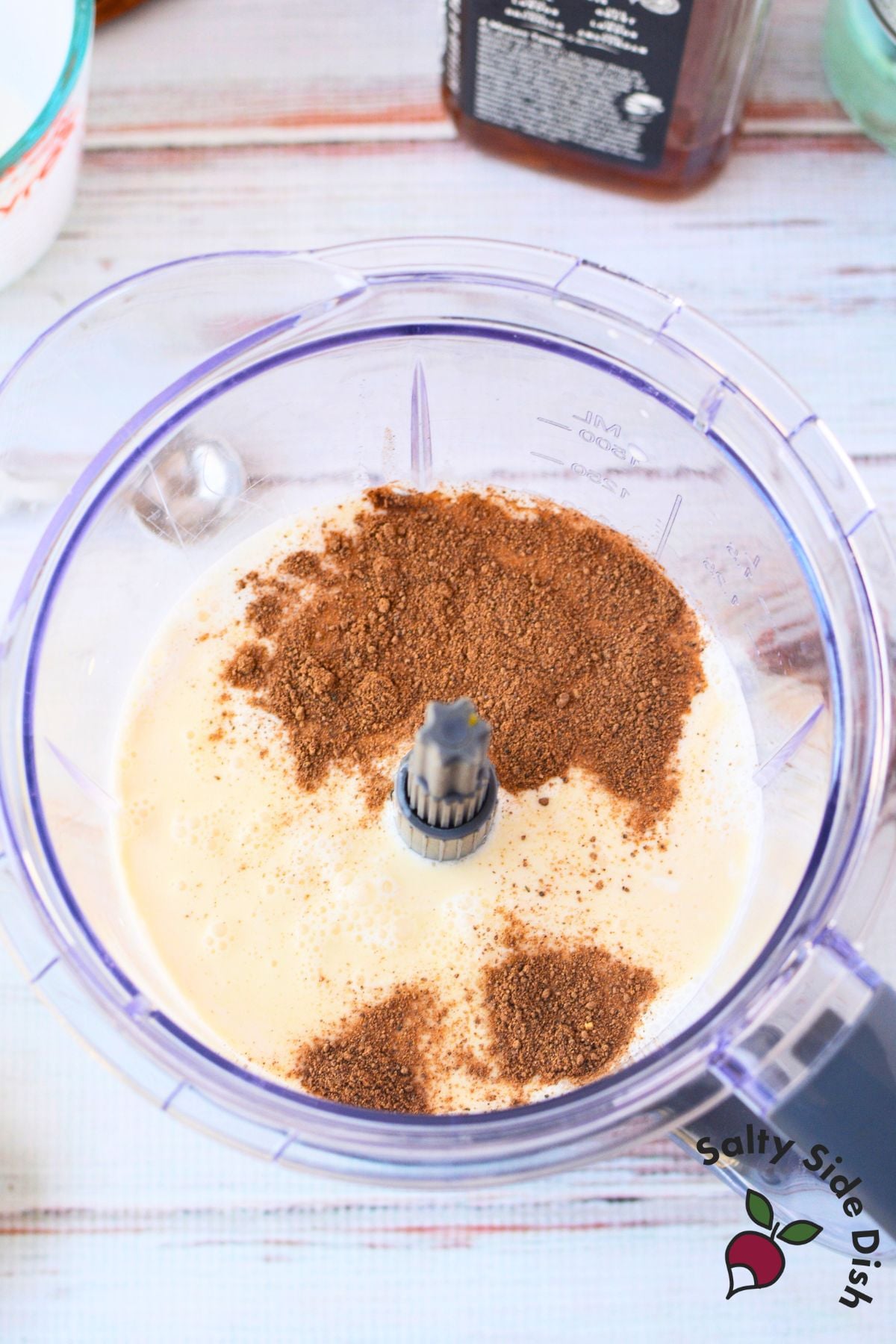 Blender filled with pasteurized eggs, milk, cream, honey, bourbon, rum, and nutmeg for spiked eggnog recipe