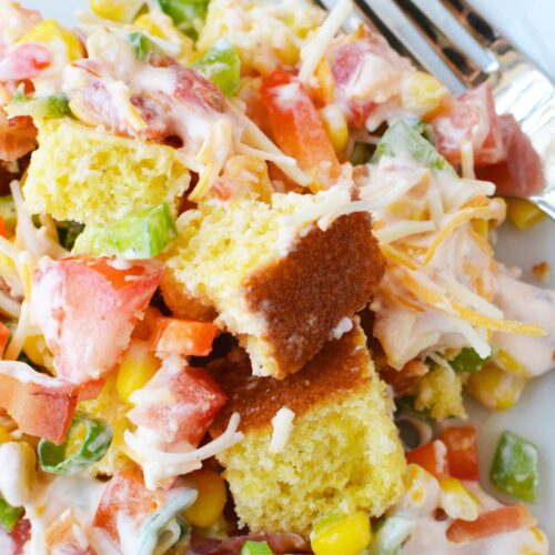 southern cornbread salad with ranch dressing bacon corn tomatoes and peppers on a plate