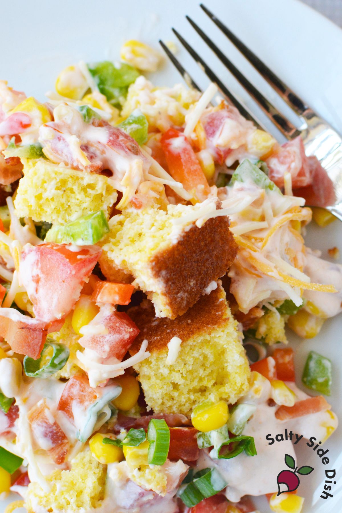 southern cornbread salad with ranch dressing bacon corn tomatoes and peppers on a plate