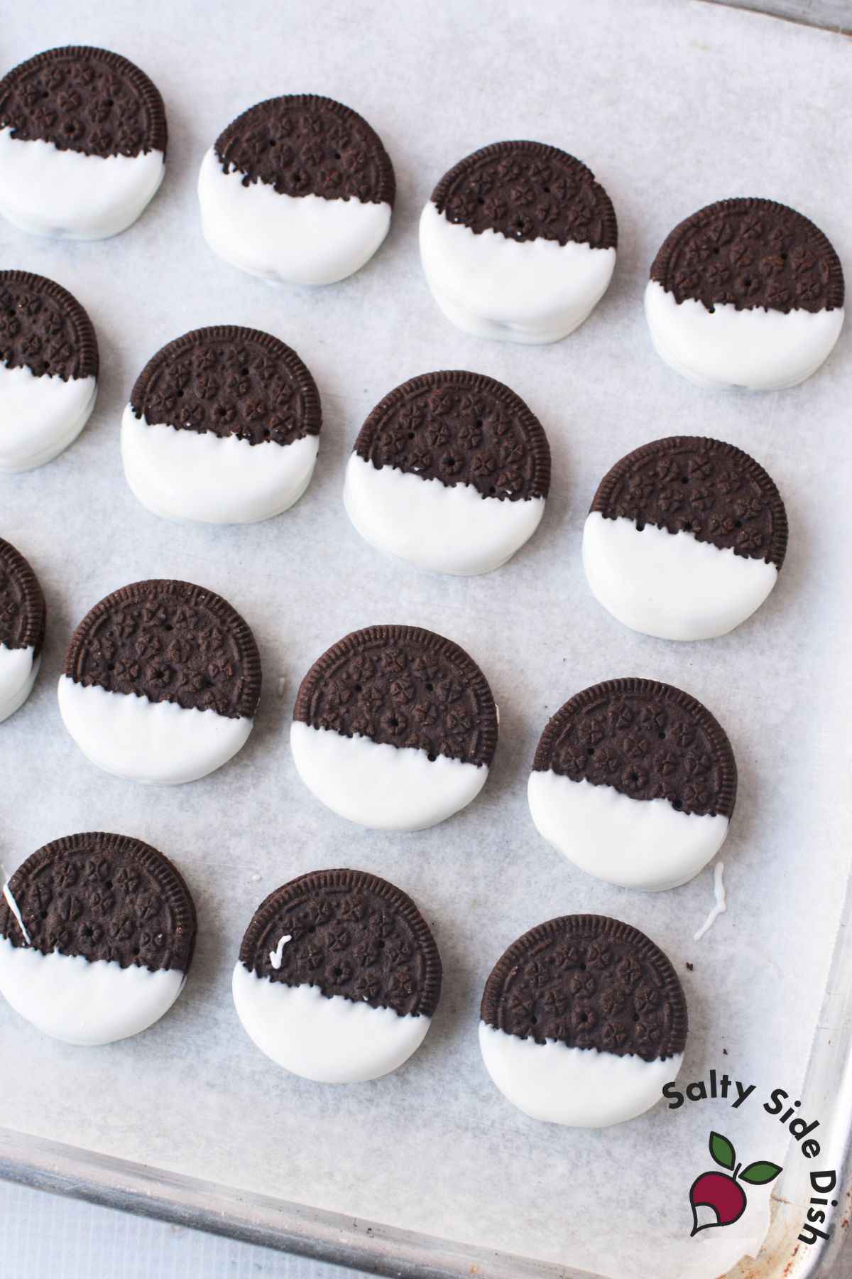 white chocolate covered oreos decorated as christmas tree cookies with star sprinkles for holiday dessert trays