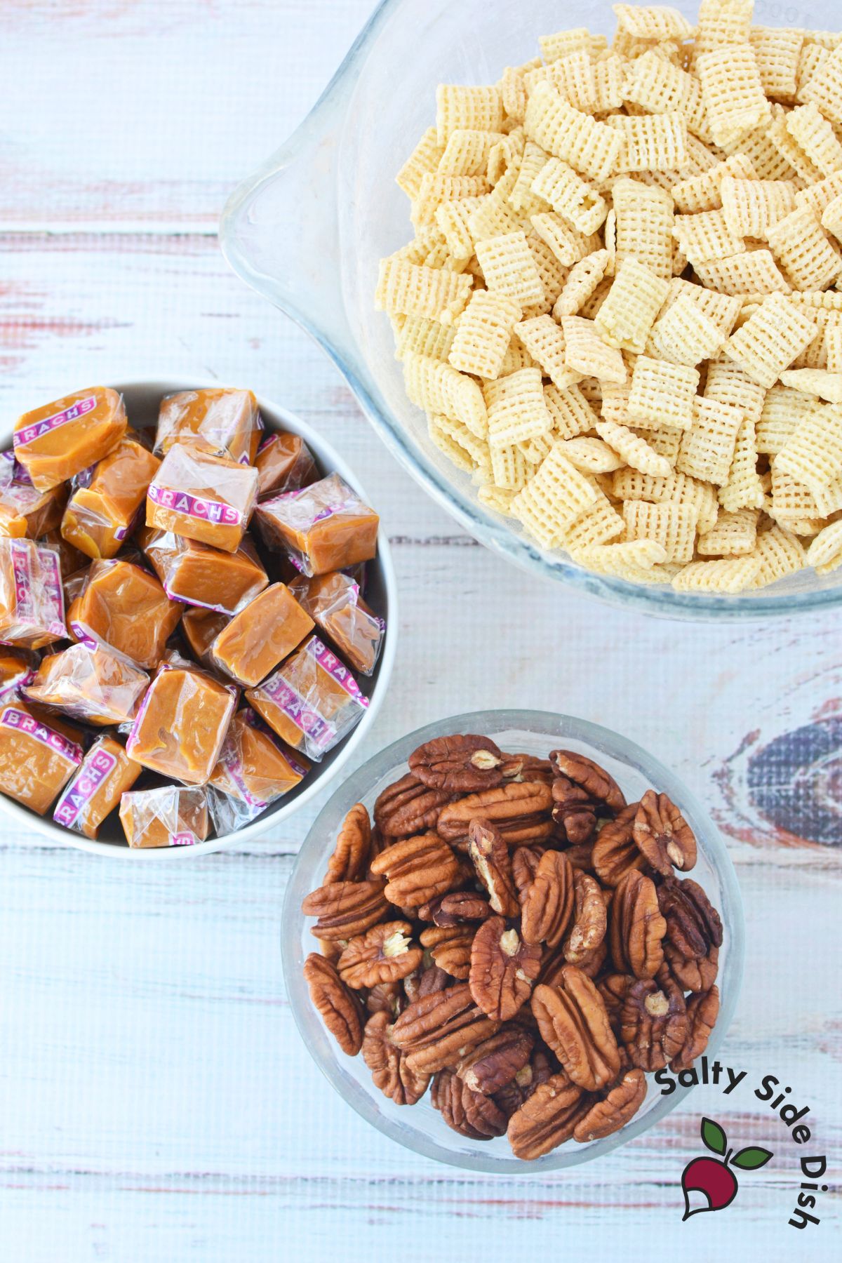 Ingredients for caramel pecan clusters including rice cereal, pecans, and wrapped caramels