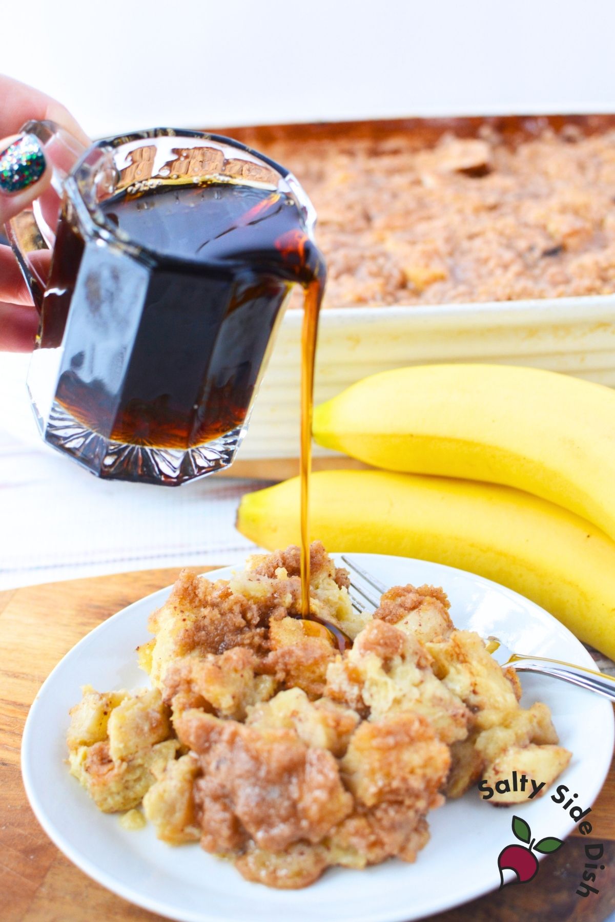pouring syrup over breakfast casserole