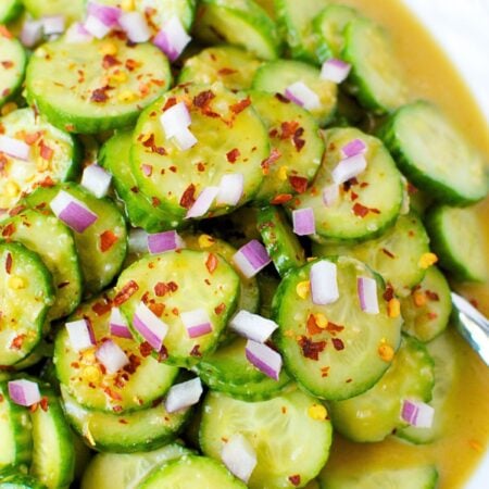 Balsamic cucumber salad with sliced cucumbers in a honey balsamic dressing topped with red onion and crushed red pepper flakes