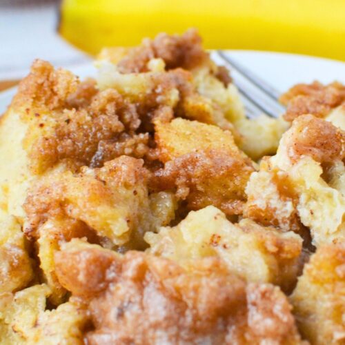 Close up of banana French toast bake with a cinnamon brown sugar crumb topping and soft custard texture