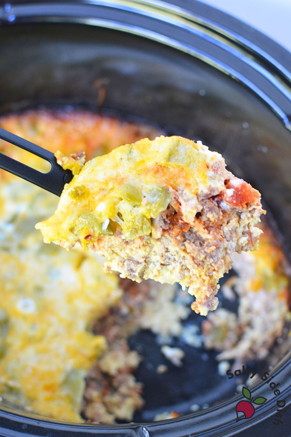 Slow cooker breakfast burrito filling made with eggs, sausage, salsa, and cheese cooked in a crock pot