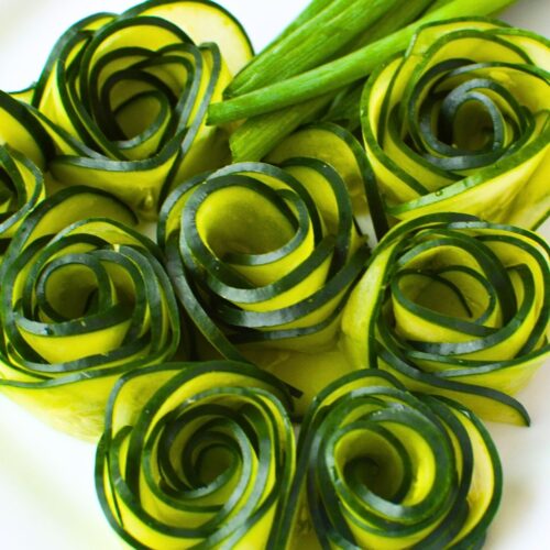 Cucumber roses arranged on a plate as a decorative garnish for charcuterie boards