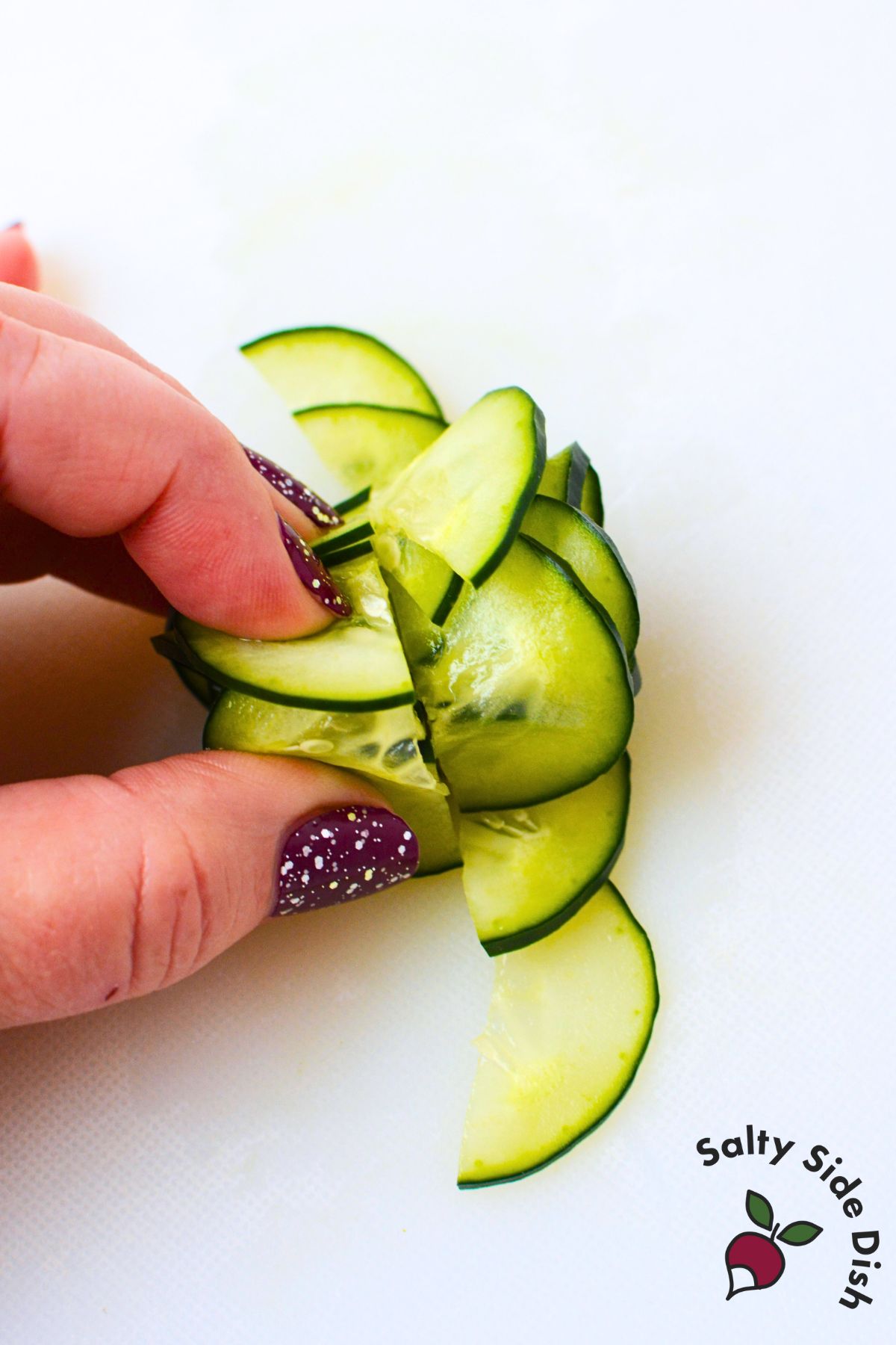 Cut cucumber slices being halved during the cucumber rose rolling process