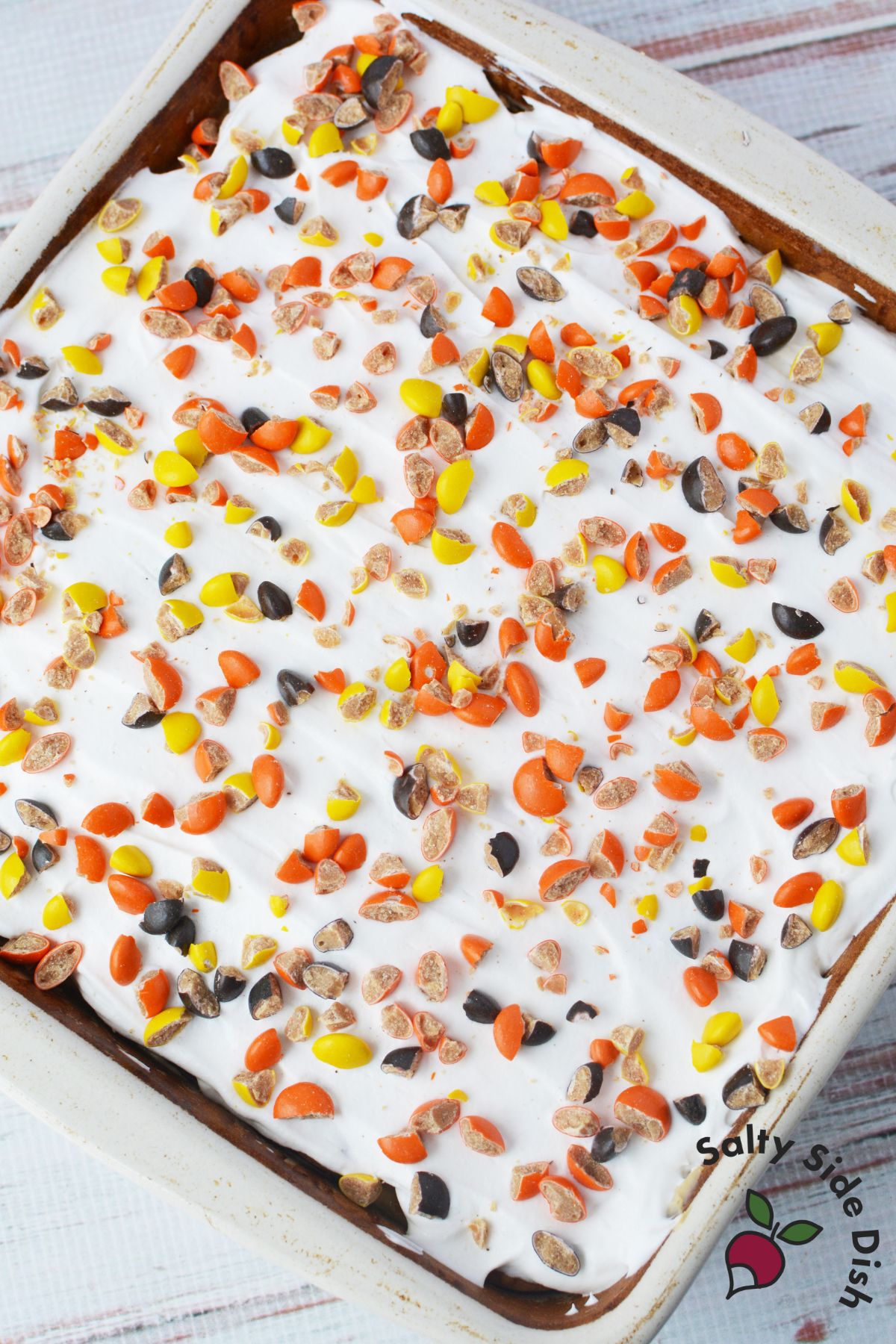 Whipped topping spread over peanut butter cookie layer in icebox cake