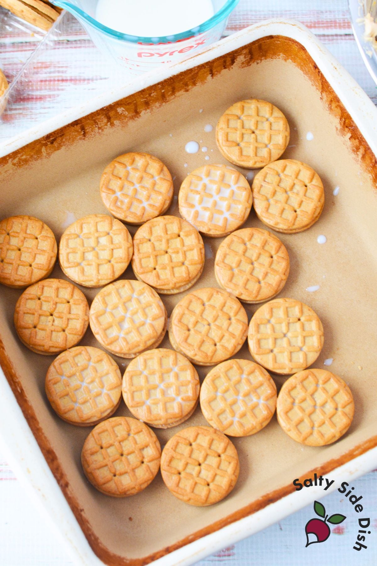 Peanut butter sandwich cookies dipped in milk before layering for icebox cake