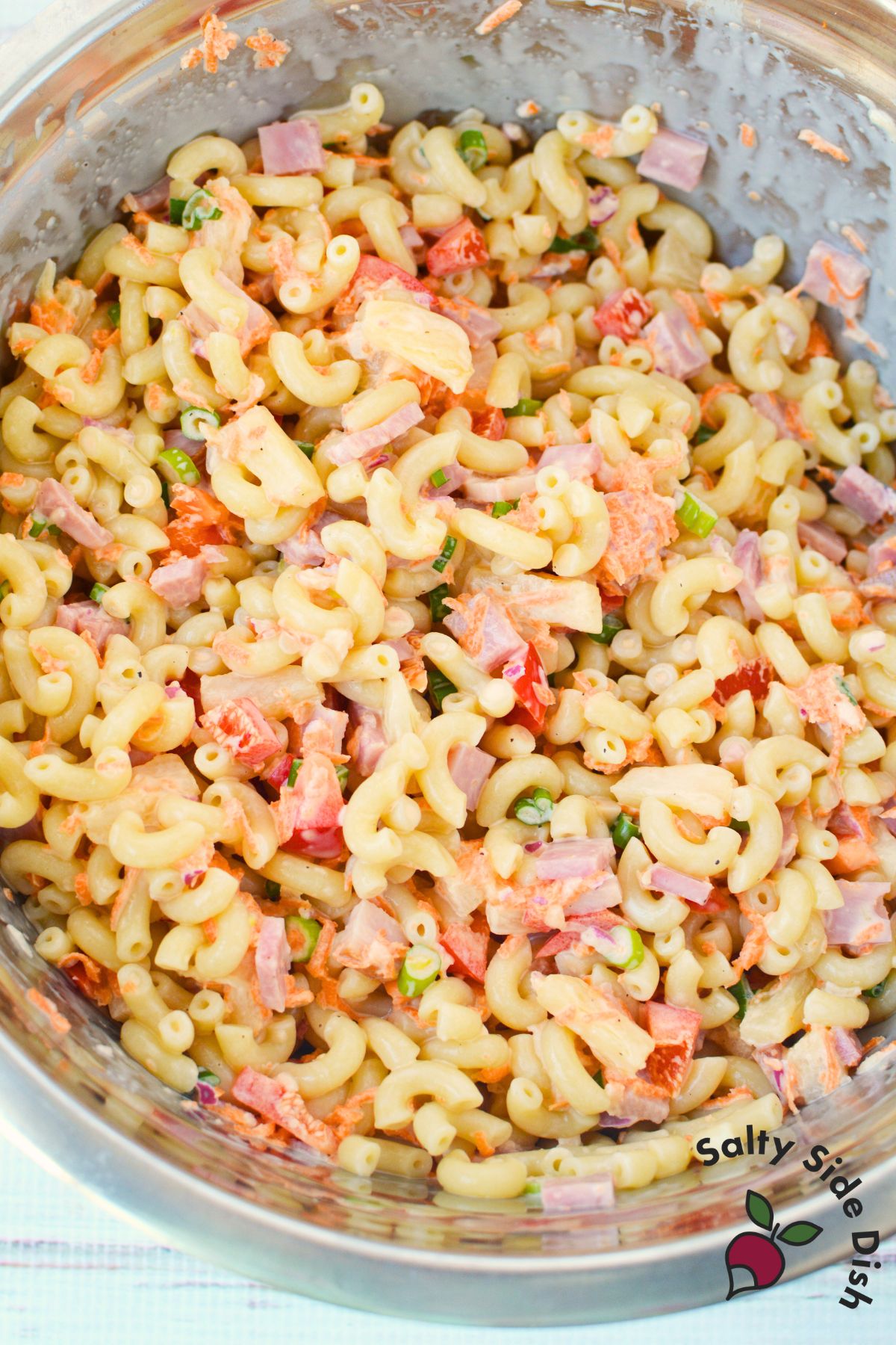 Mixed Hawaiian pasta salad in a glass bowl showing creamy pasta dressing coating the ingredients