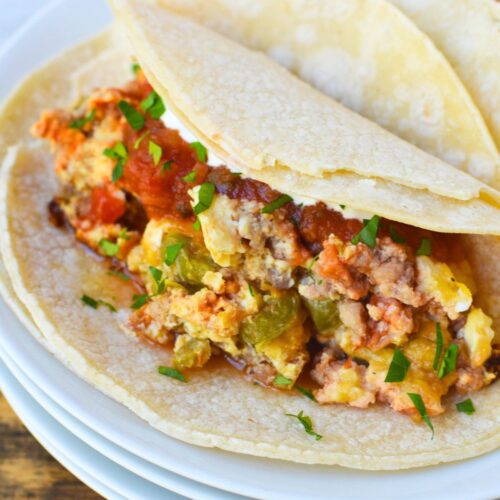 Recipe for crockpot eggs layered with sausage, salsa, peppers, and cheese before cooking