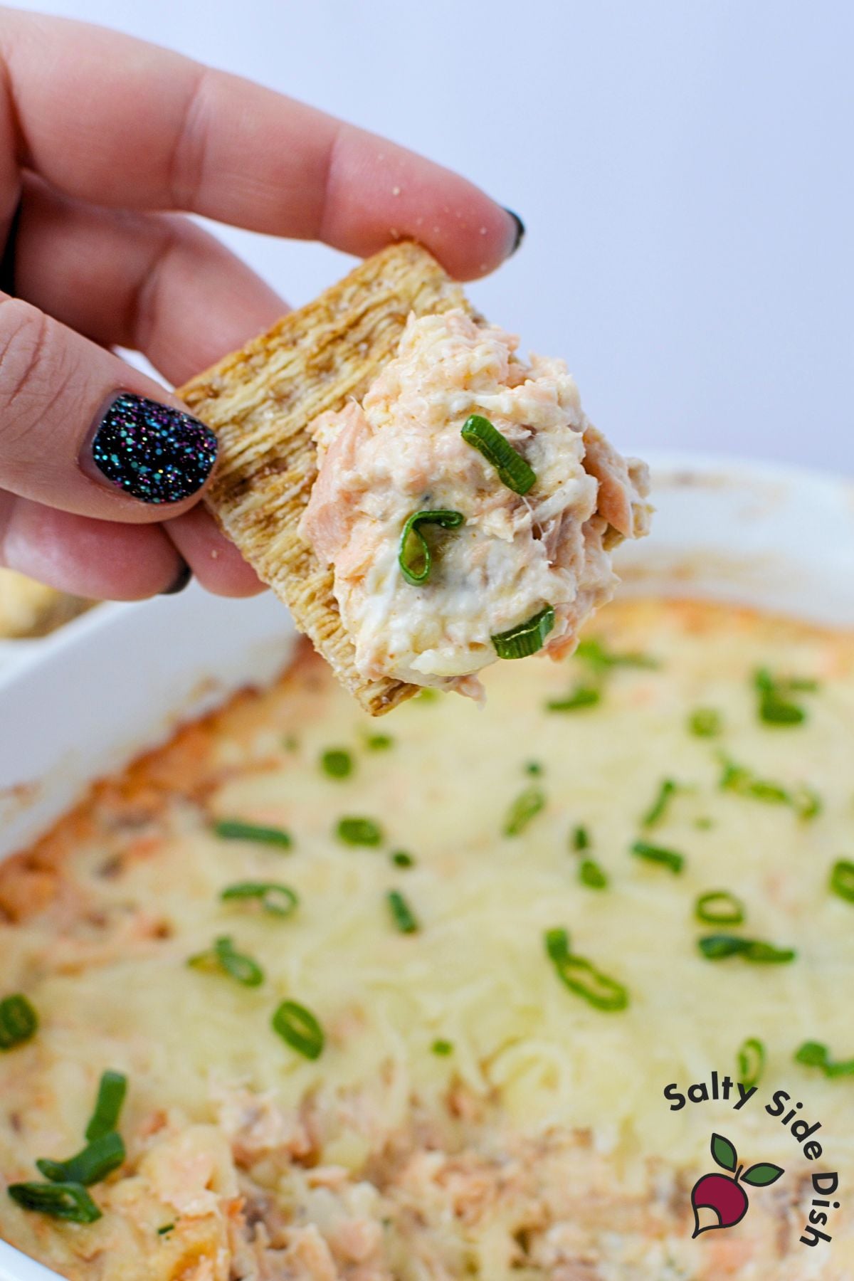 Close up of creamy baked salmon dip showing cheesy texture after serving
