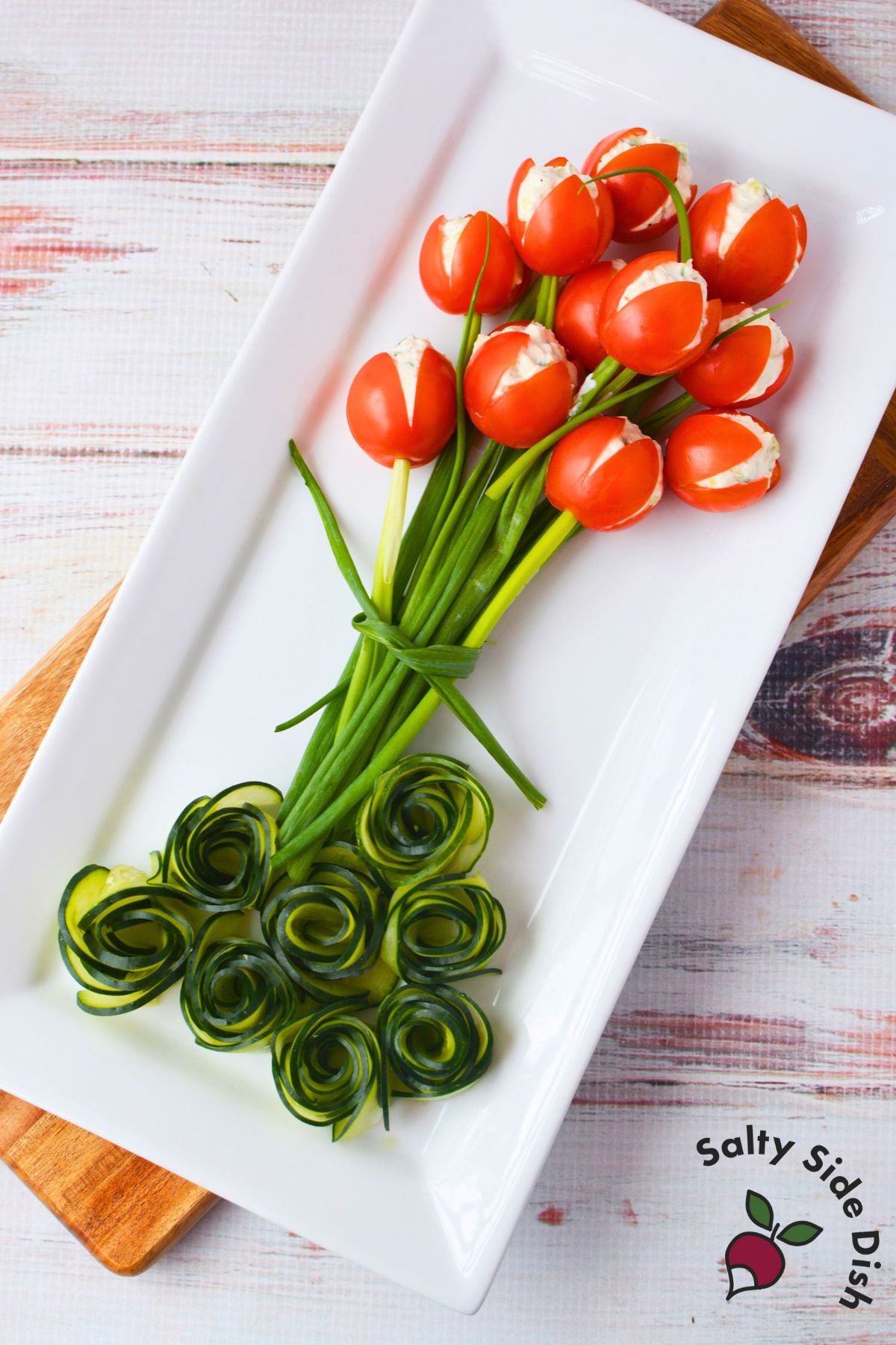 Hollowed cherry tomato on a skewer prepared for filling to make tulip tomatoes