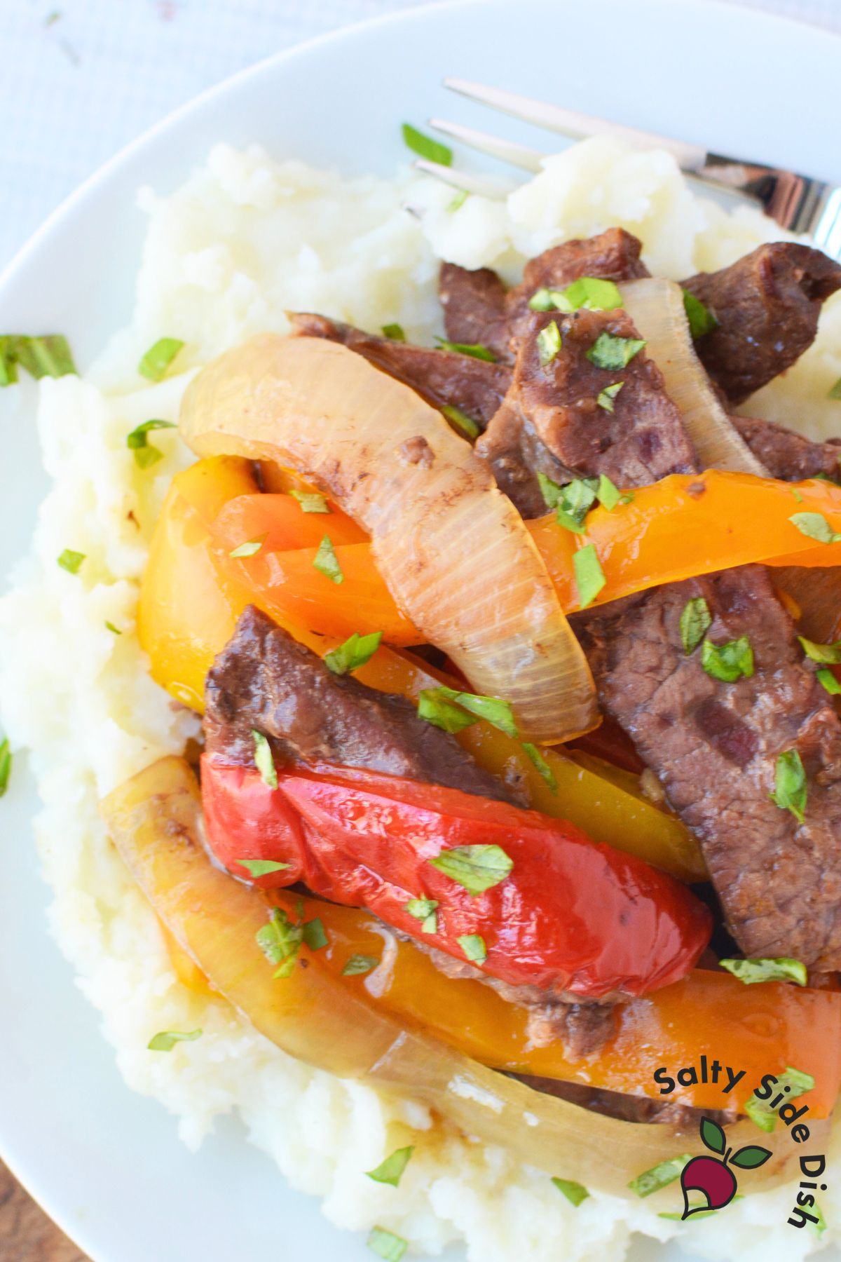 Crock pot steak and peppers recipe served over rice with tender beef and soft bell peppers