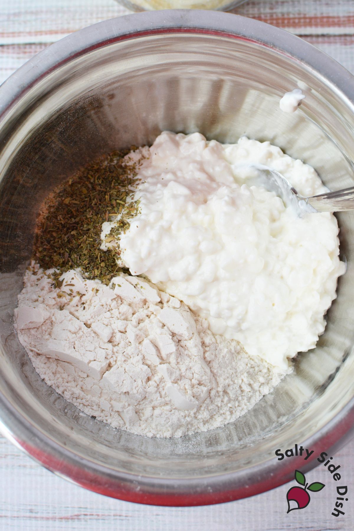 flour, cottage cheese, and Italian seasoning in a stainless steel mixing bowl before combining