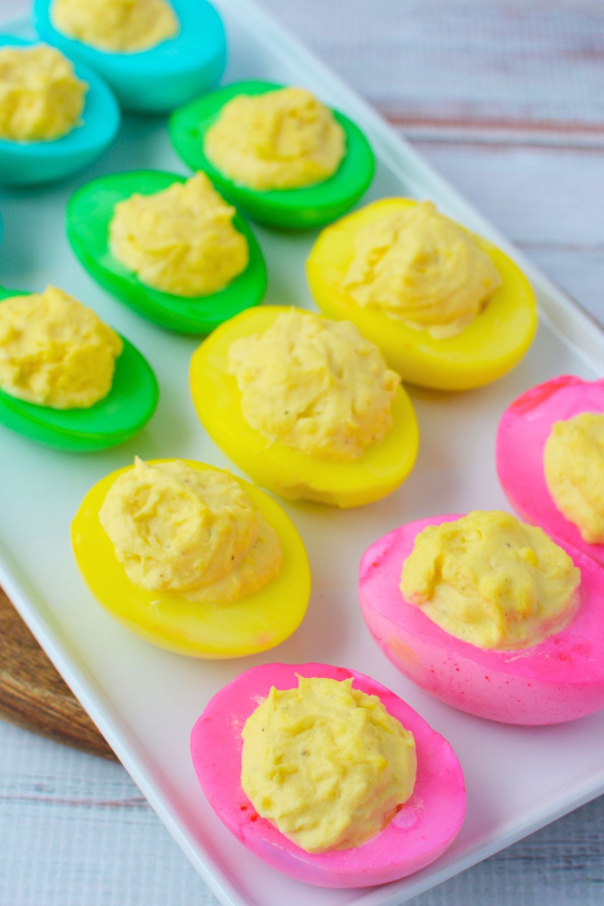 colorful deviled eggs arranged on a white platter for Easter appetizers