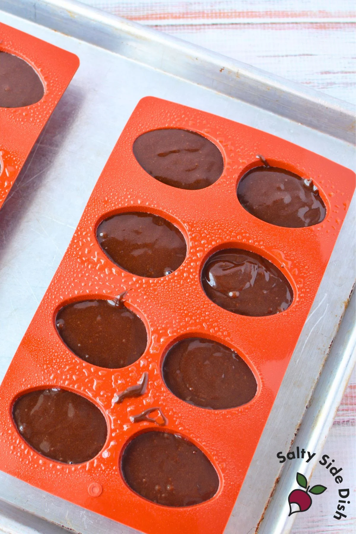 Chocolate brownie batter poured into silicone egg-shaped molds before baking