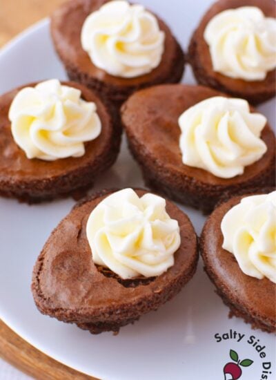Easter egg brownies topped with piped cream cheese marshmallow filling on white plate