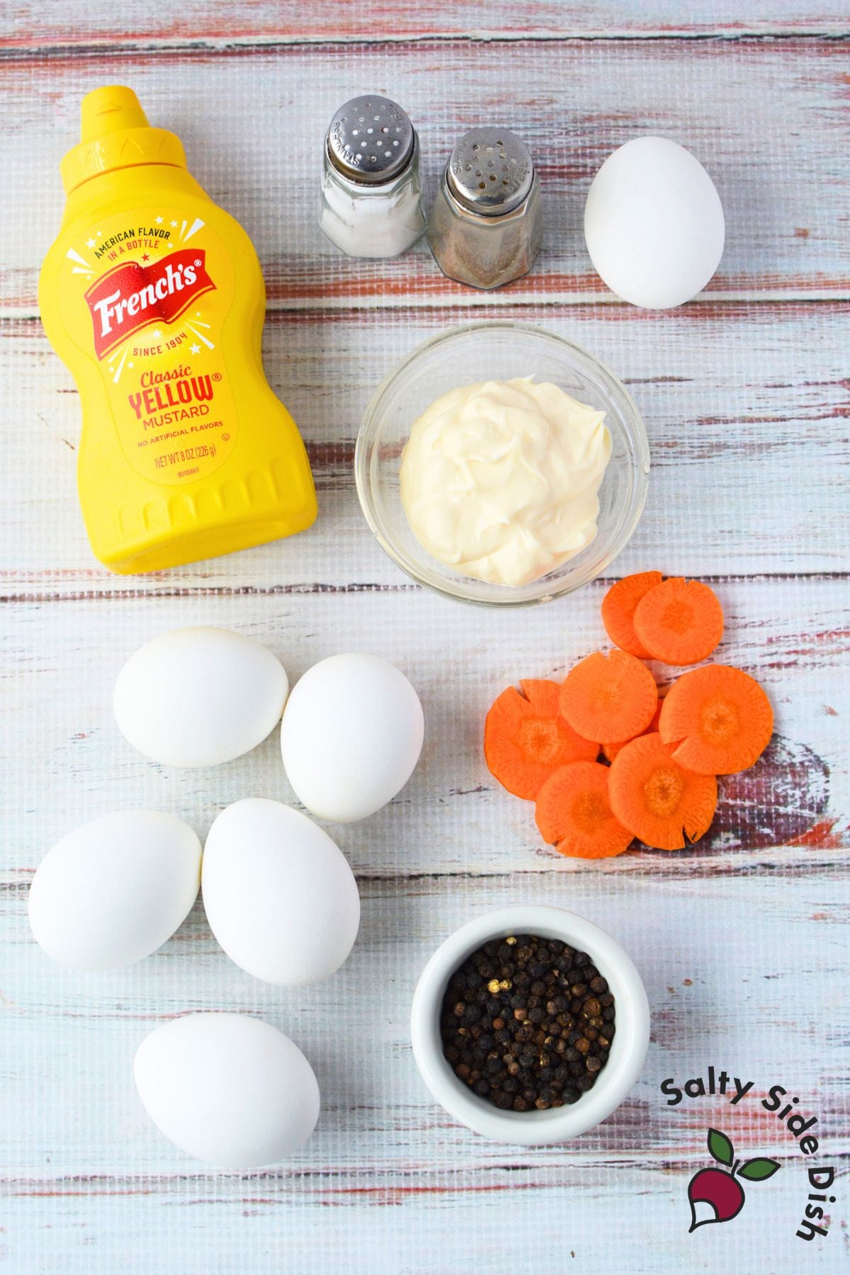 ingredients for chick deviled eggs including eggs, mayonnaise, mustard, carrots, and peppercorns