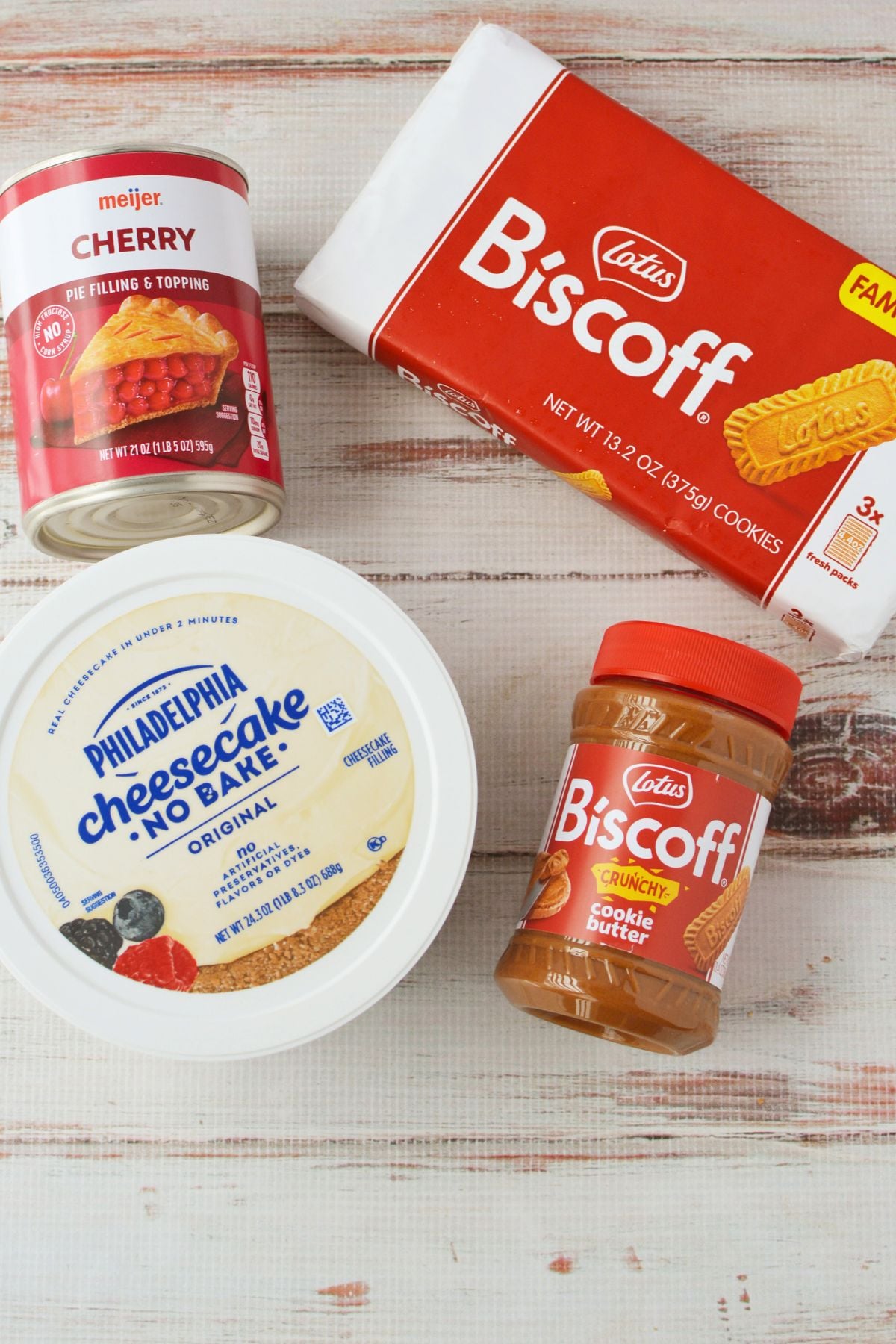 Ingredients for Biscoff cherry cheesecake including no bake cheesecake, cherry pie filling, Biscoff cookies, and cookie butter