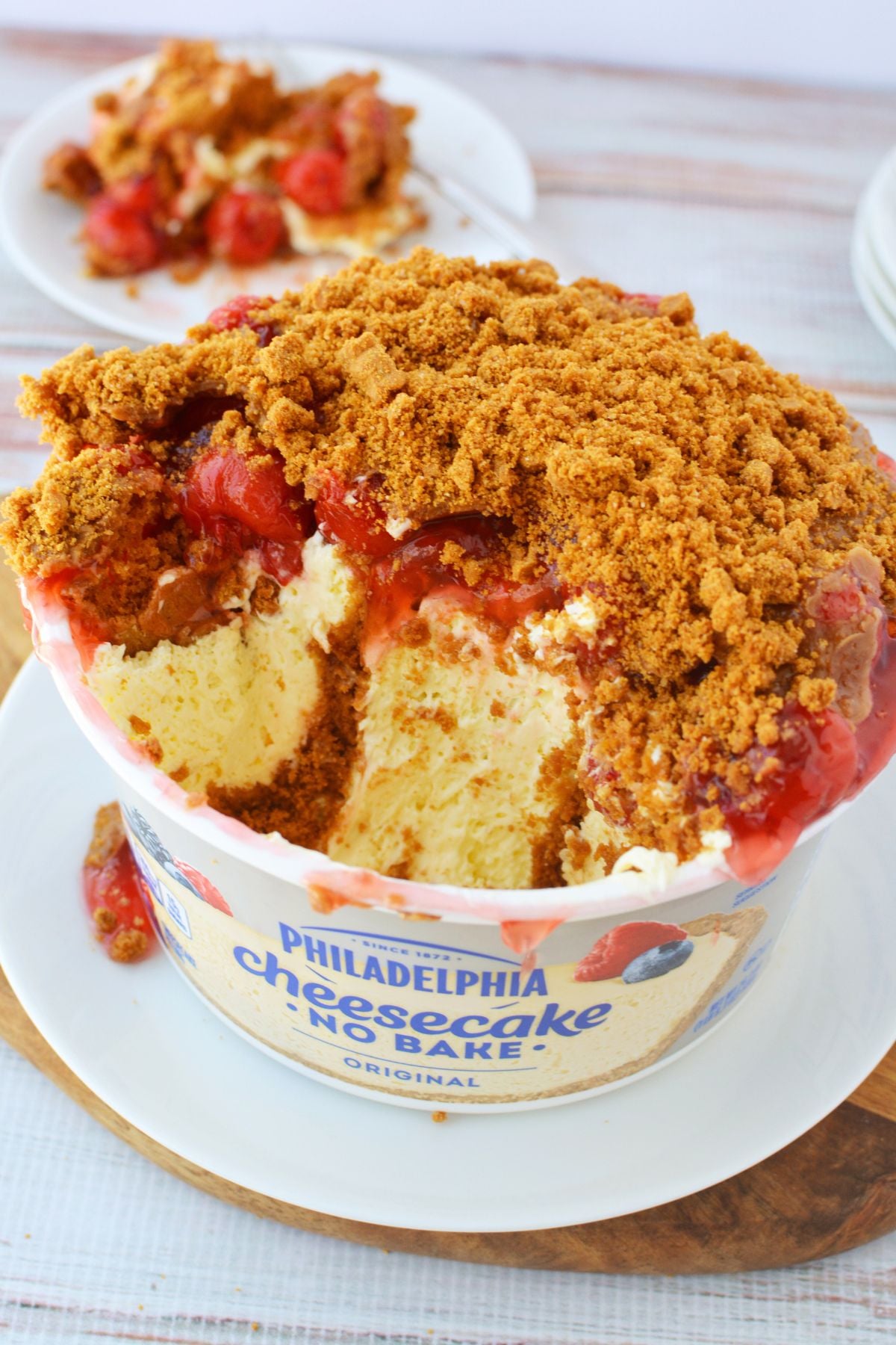 Philadelphia no bake cheesecake layered with cherry pie filling and crushed Biscoff cookies in original container