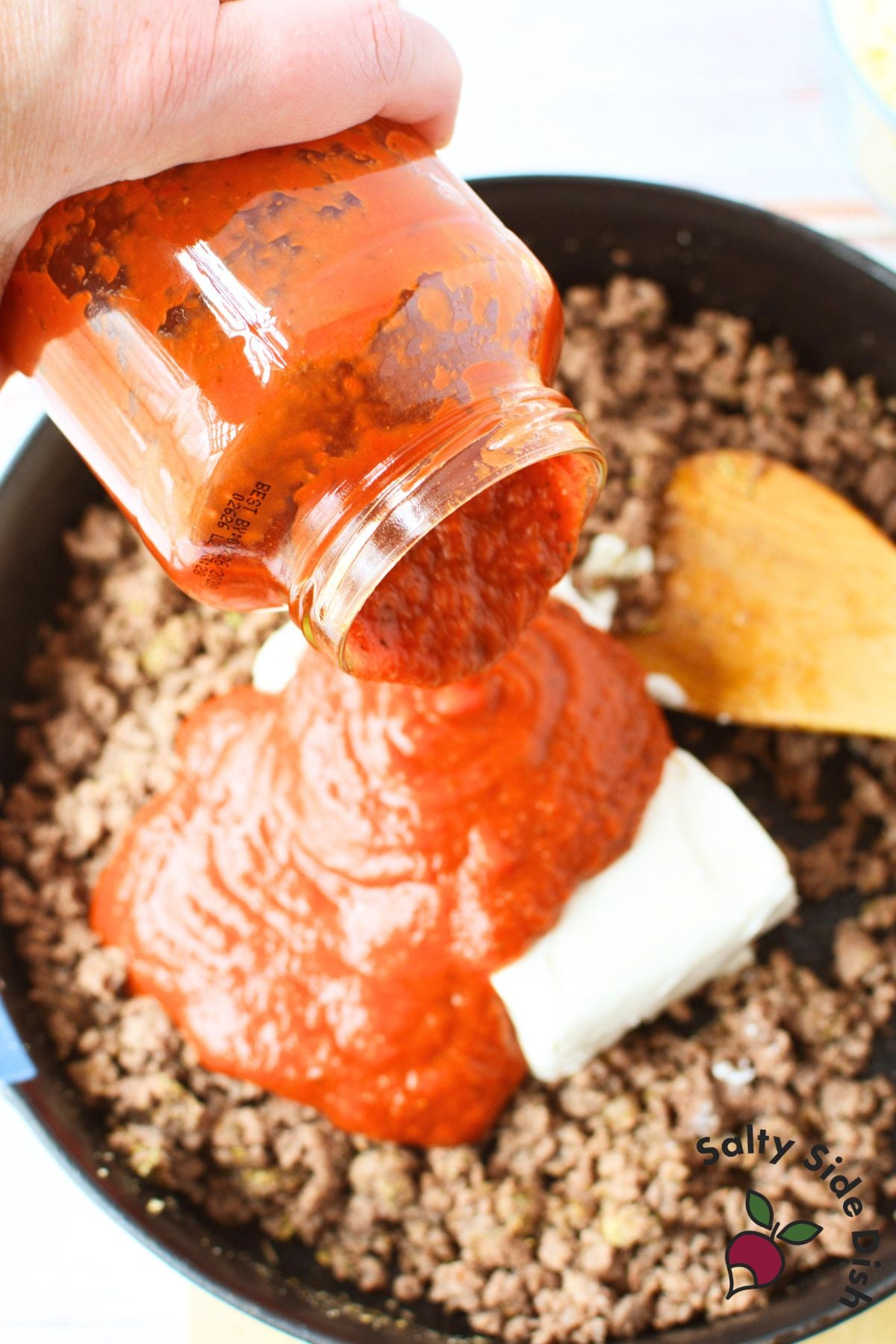 viral recipe pasta with ground beef and cream cheese sauce being poured into skillet