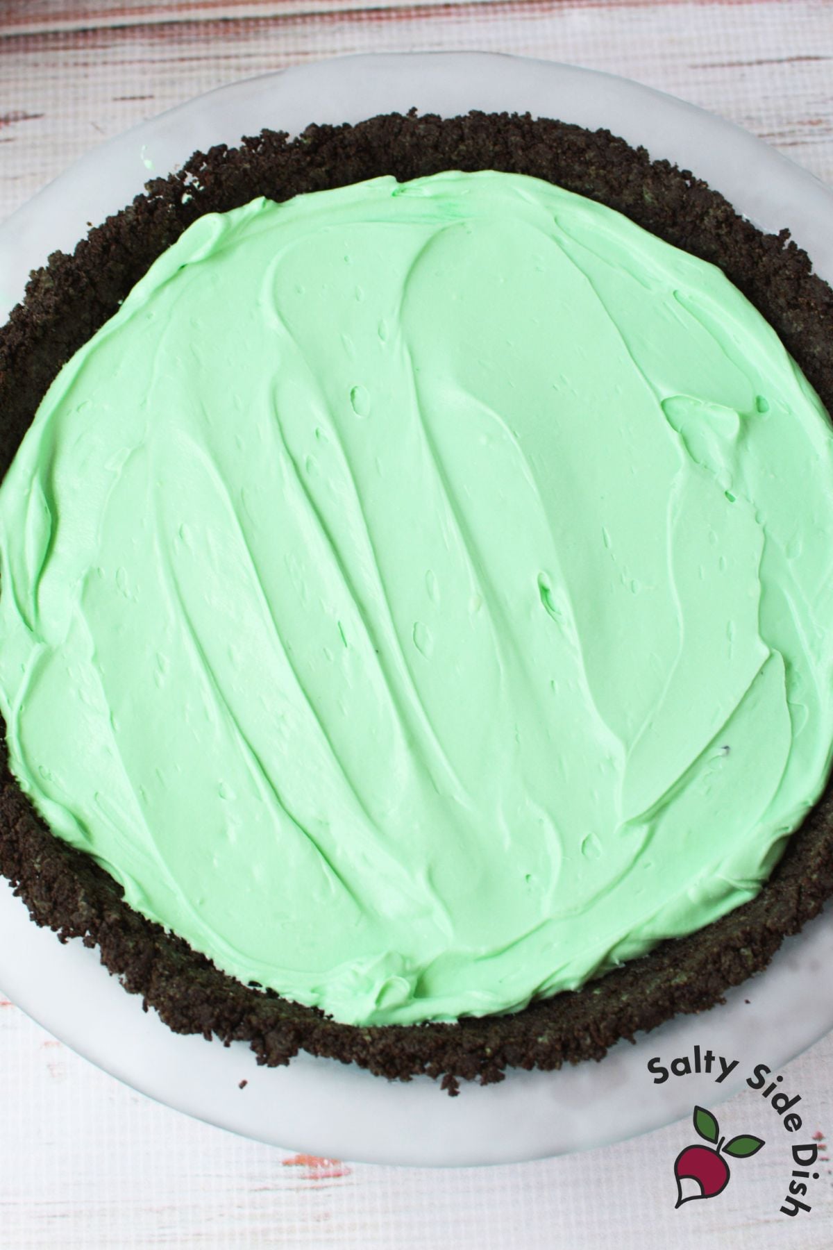 mint grasshopper pie filling spread into oreo crust