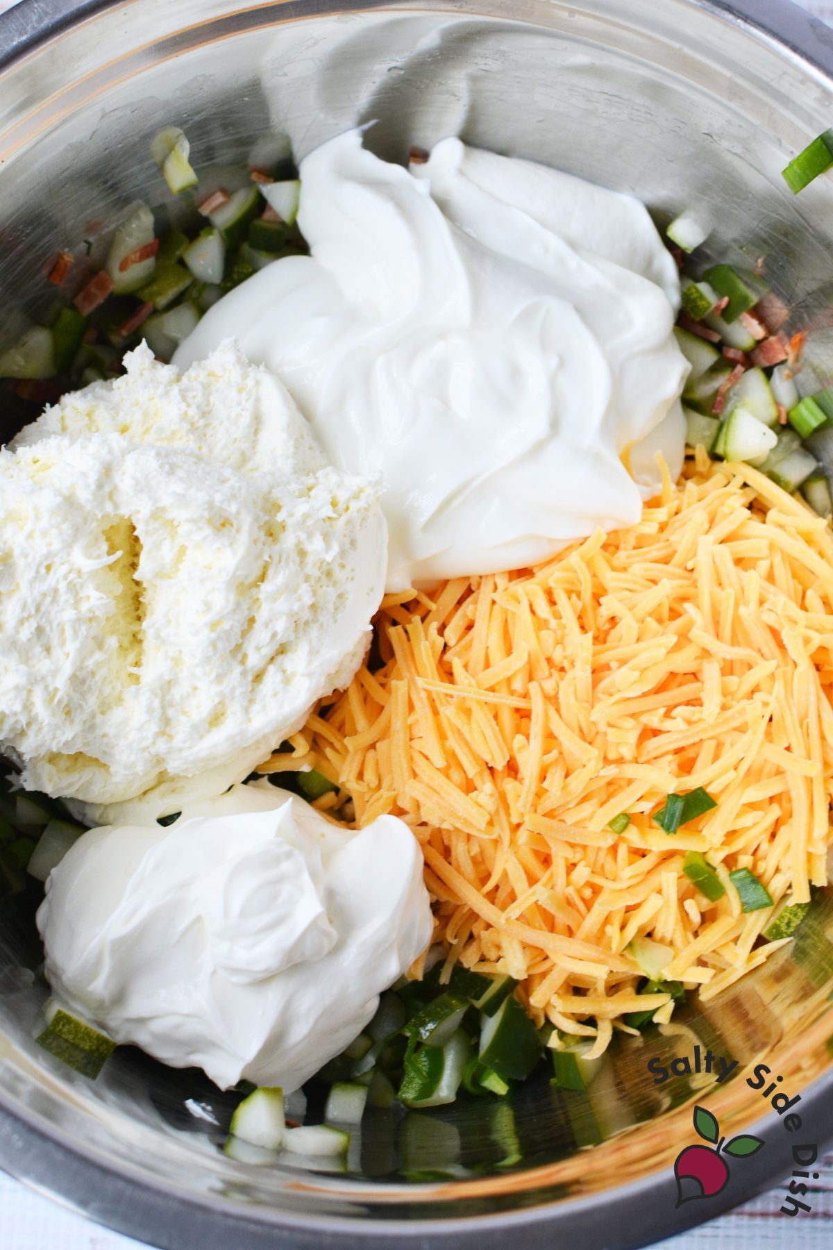 Cream cheese, sour cream, and shredded cheddar added to pickle mixture for Grillo’s pickle dip