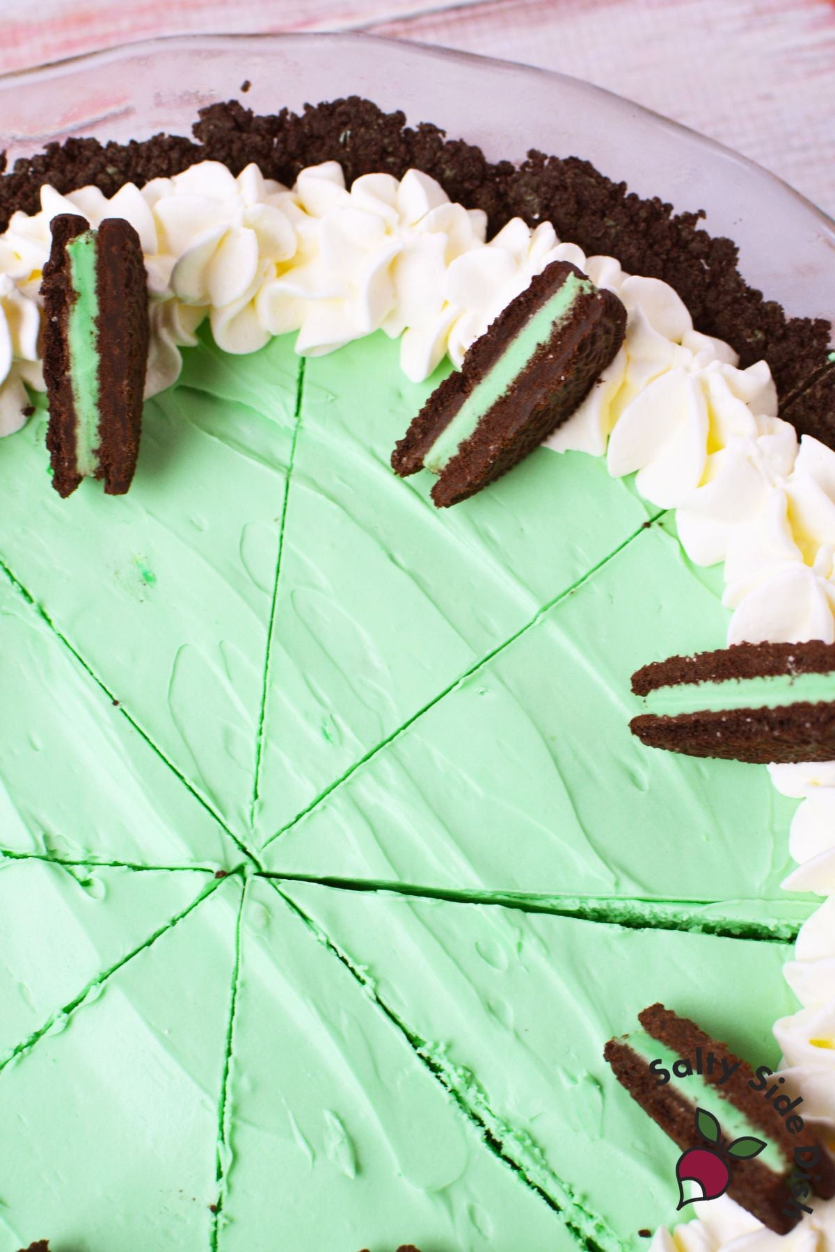 top view of grasshopper pie sliced with whipped cream and oreo garnish