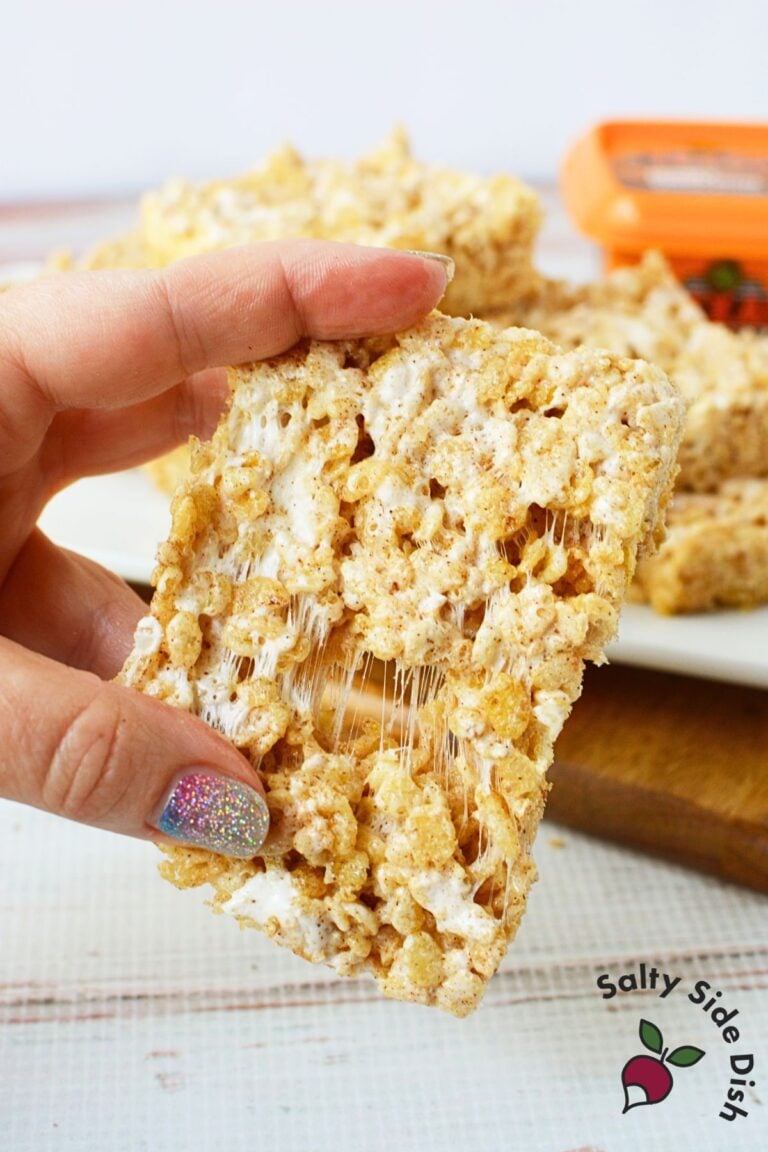 Texas Roadhouse Rice Krispie Treats stacked on plate with honey cinnamon butter in background