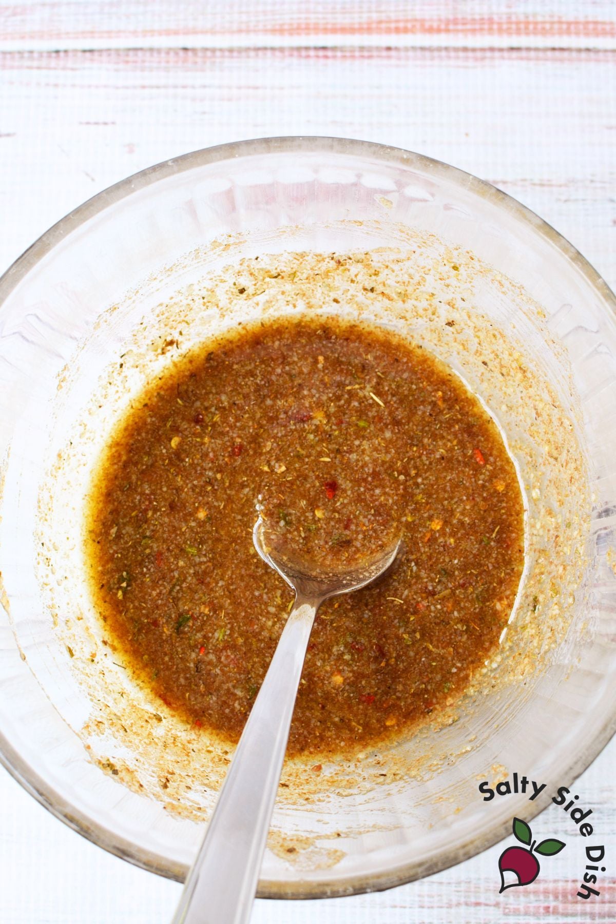 Close up of olive oil balsamic vinegar bread dip with herbs, parmesan, and crusty bread