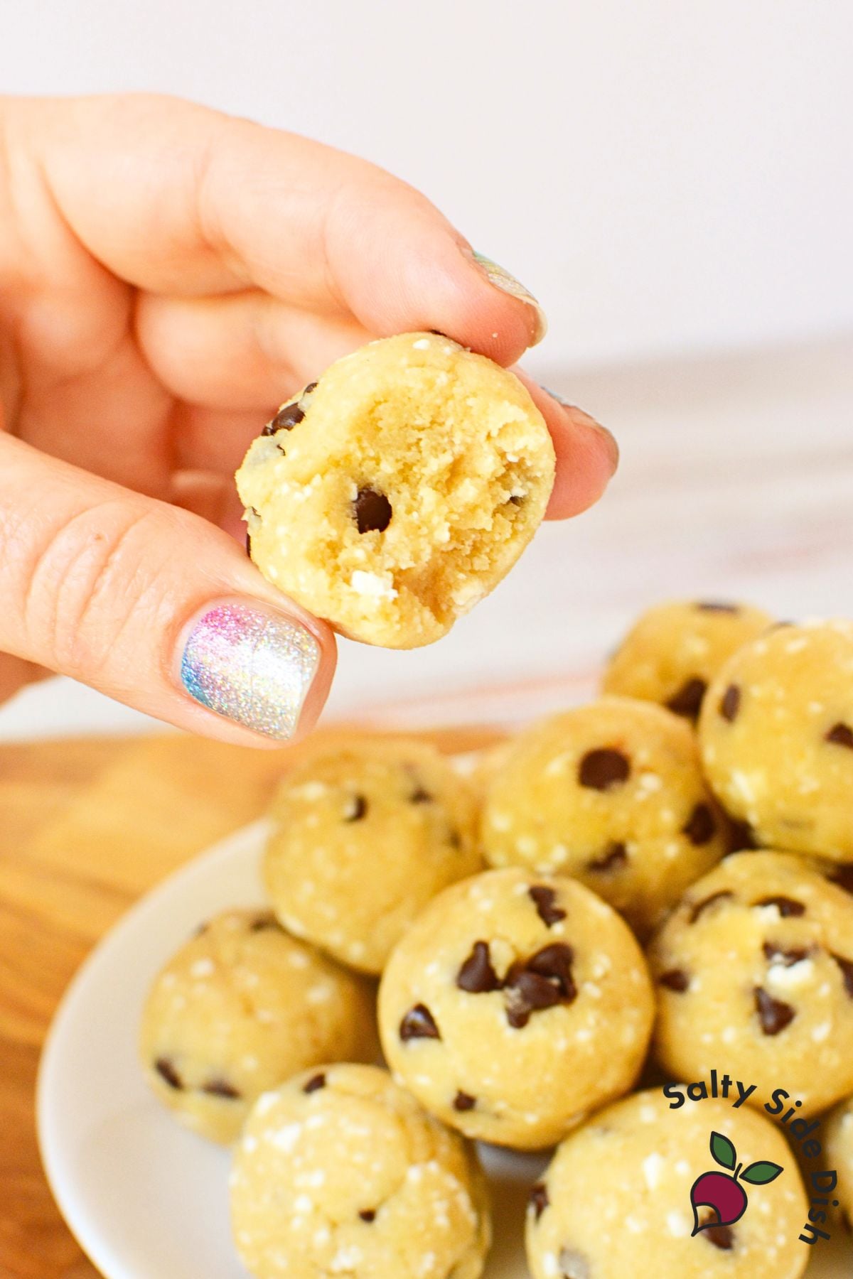 hand holding bite out of cottage cheese cookie dough balls