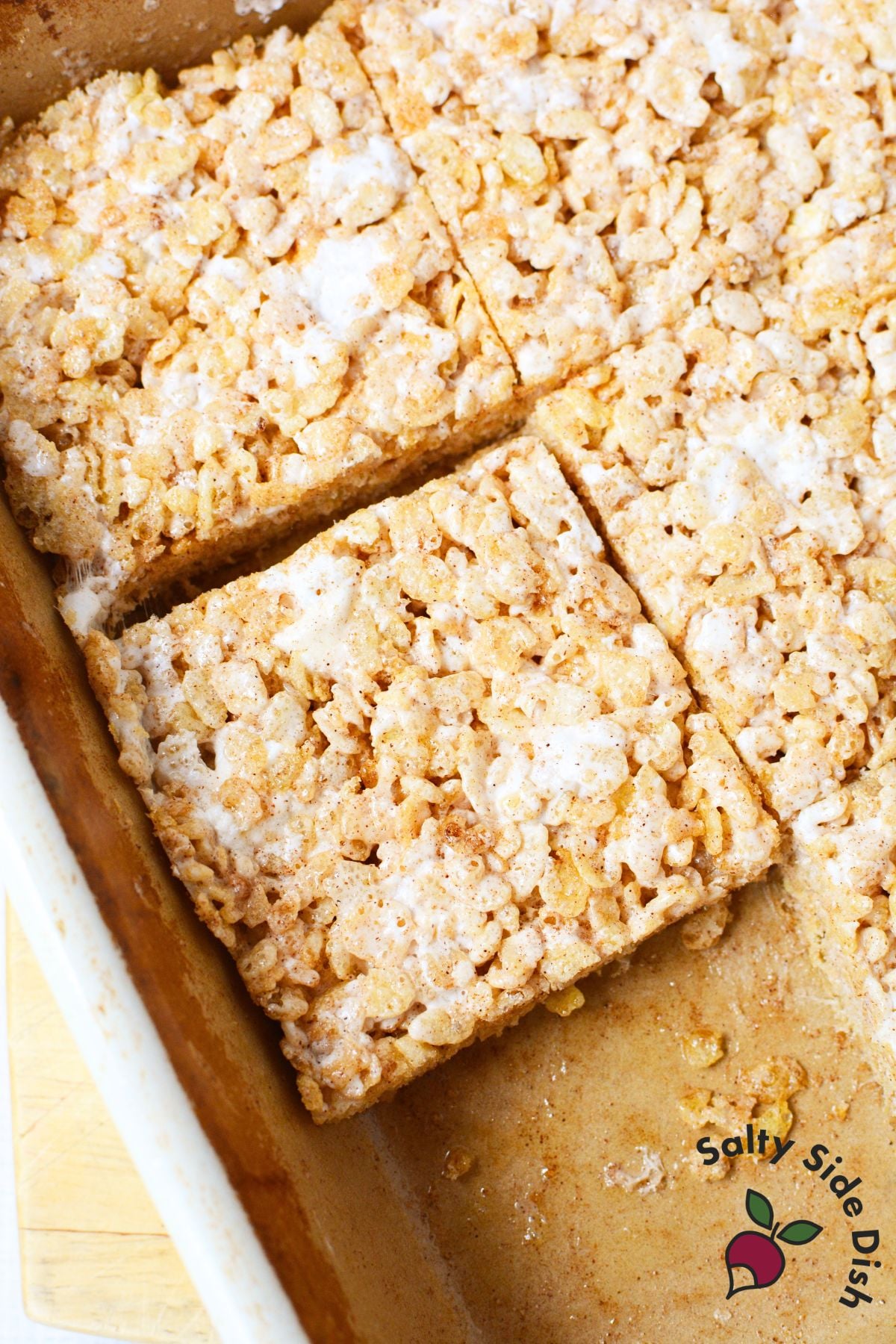Cut Texas Roadhouse Rice Krispie Treats in baking dish with cinnamon sugar and melted marshmallow topping