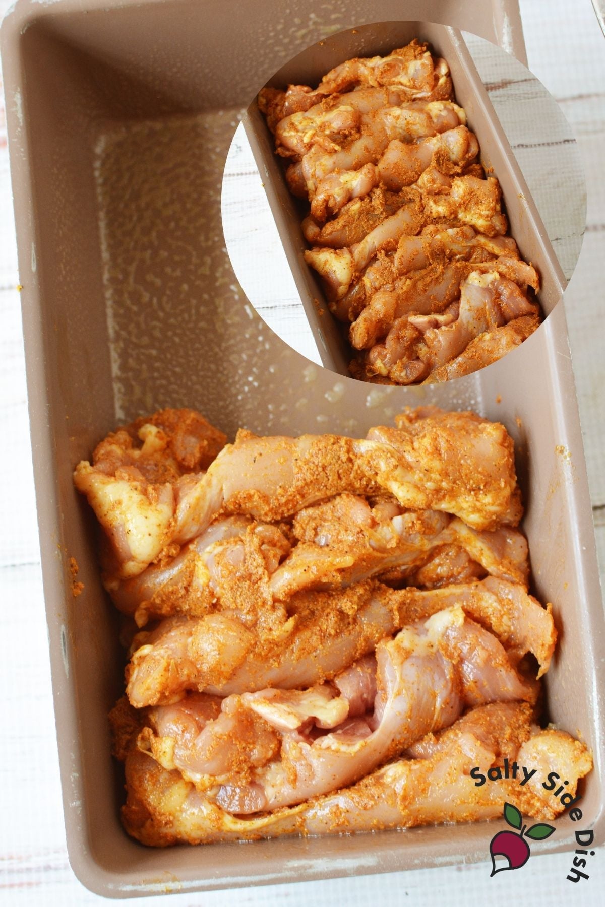 Batch-cooked seasoned chicken thighs arranged in a loaf pan before baking