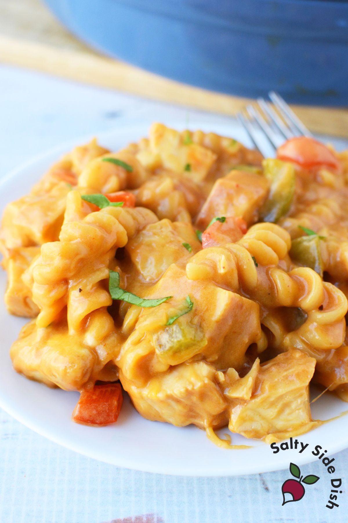 Plated serving of creamy fajita chicken mac and cheese topped with fresh herbs