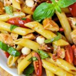 Close up of bruschetta chicken bacon pasta with basil and mozzarella pearls