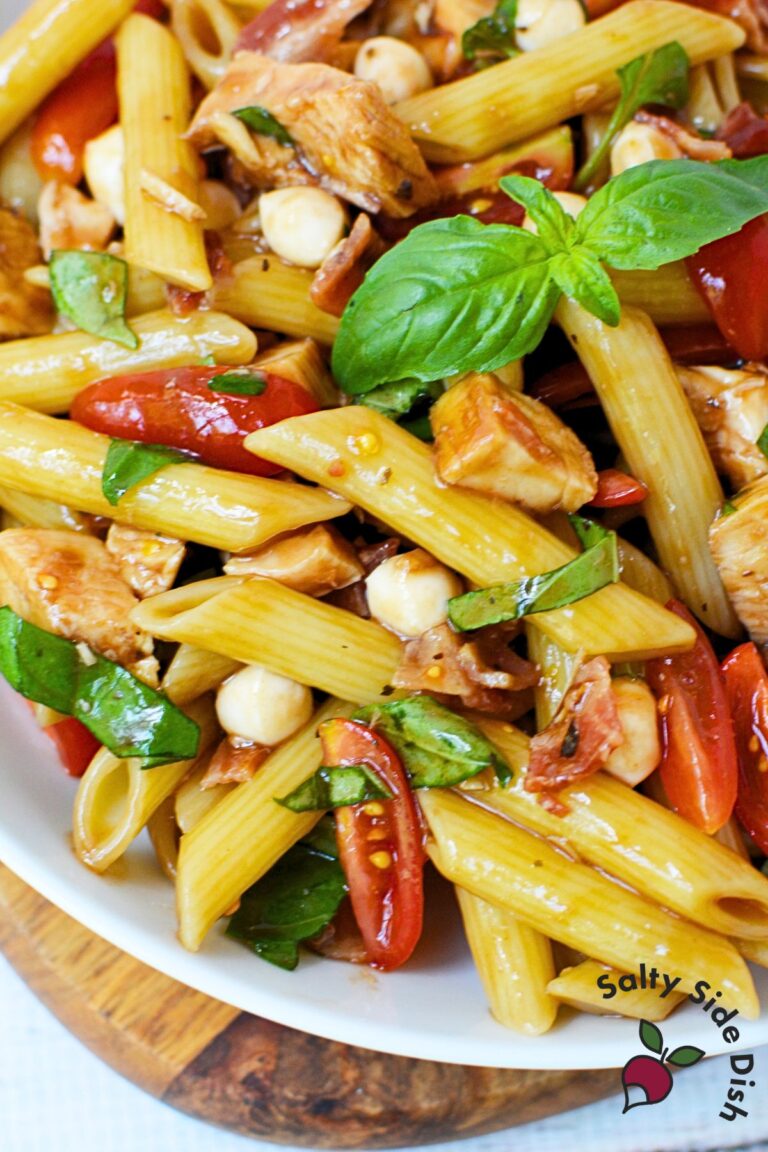 Close up of bruschetta chicken bacon pasta with basil and mozzarella pearls