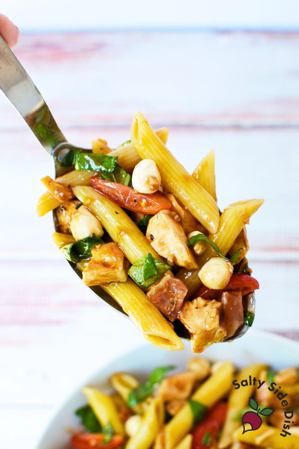 Spoonful of bruschetta chicken bacon pasta with tomatoes and basil