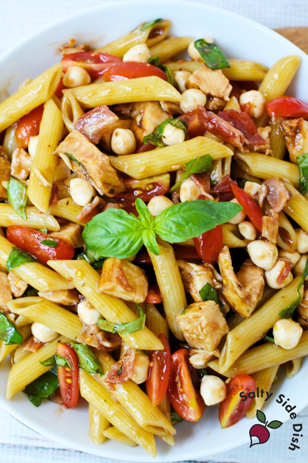 Bowl of bruschetta chicken bacon pasta with balsamic glaze
