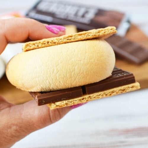 Hand holding a smore made with an air fried marshmallow and chocolate bar