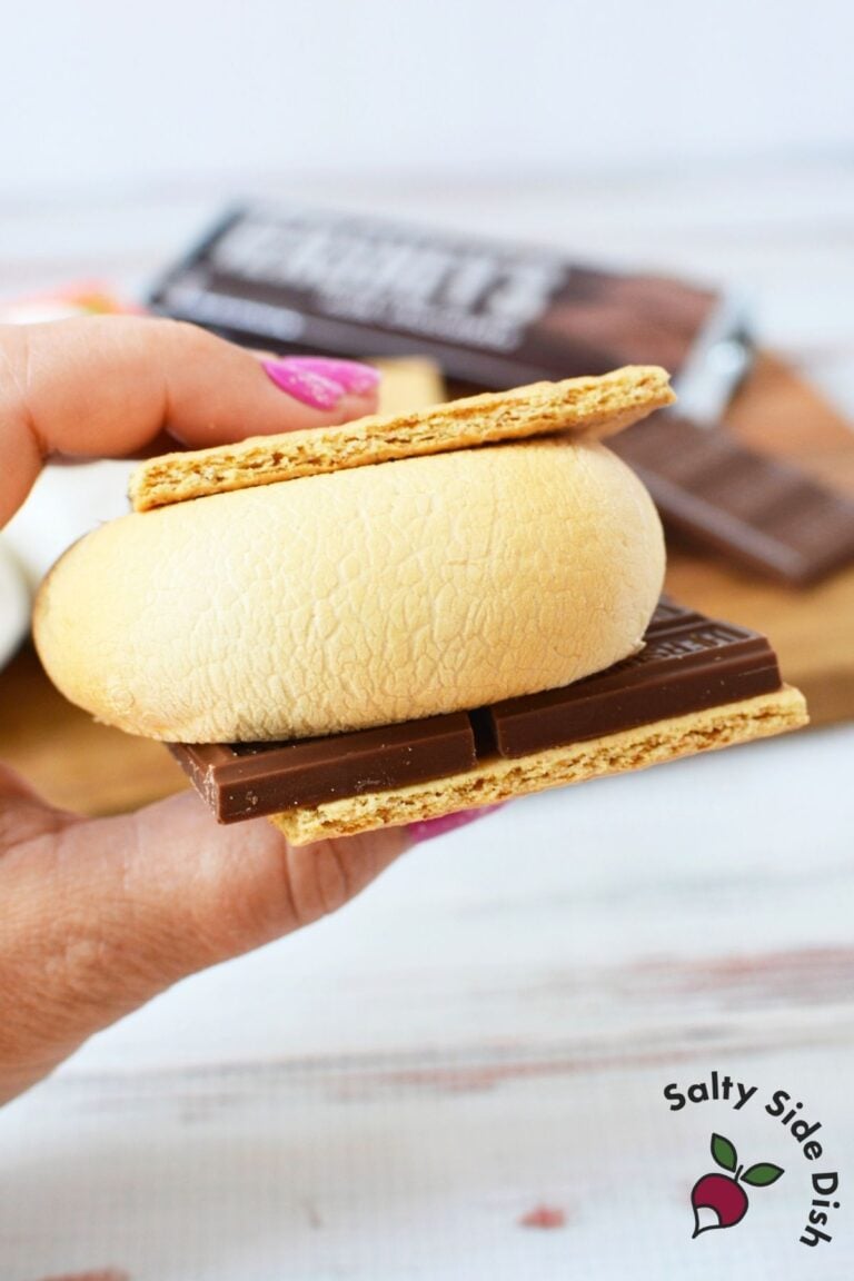 Hand holding a smore made with an air fried marshmallow and chocolate bar