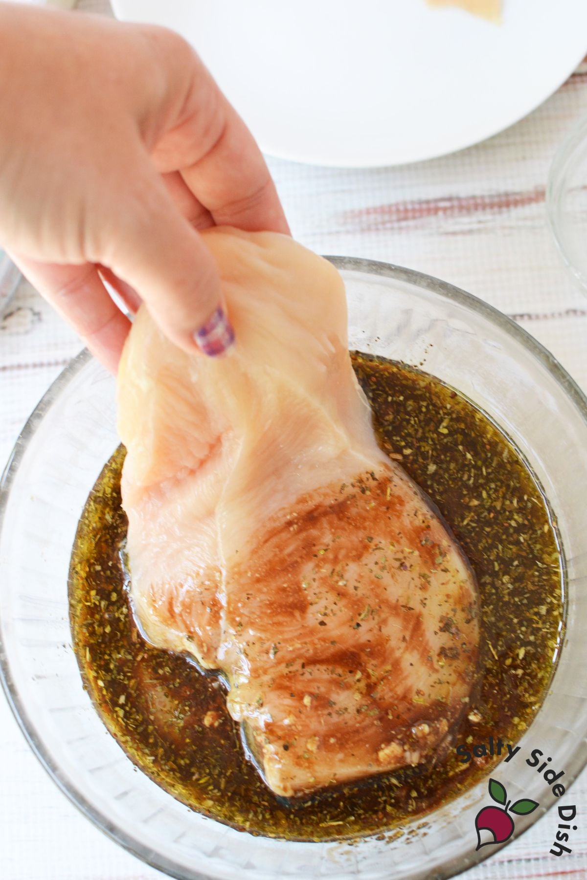 Raw chicken breast dipped into balsamic herb marinade