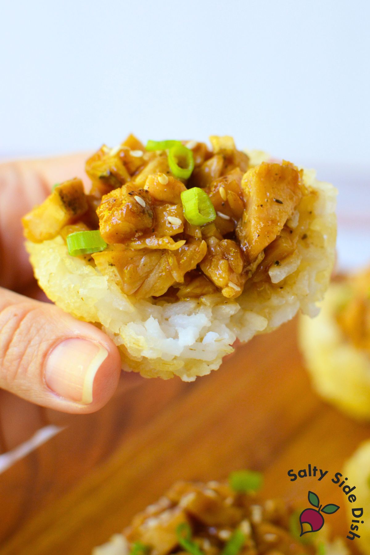 Close up of a chicken teriyaki rice cup topped with green onion