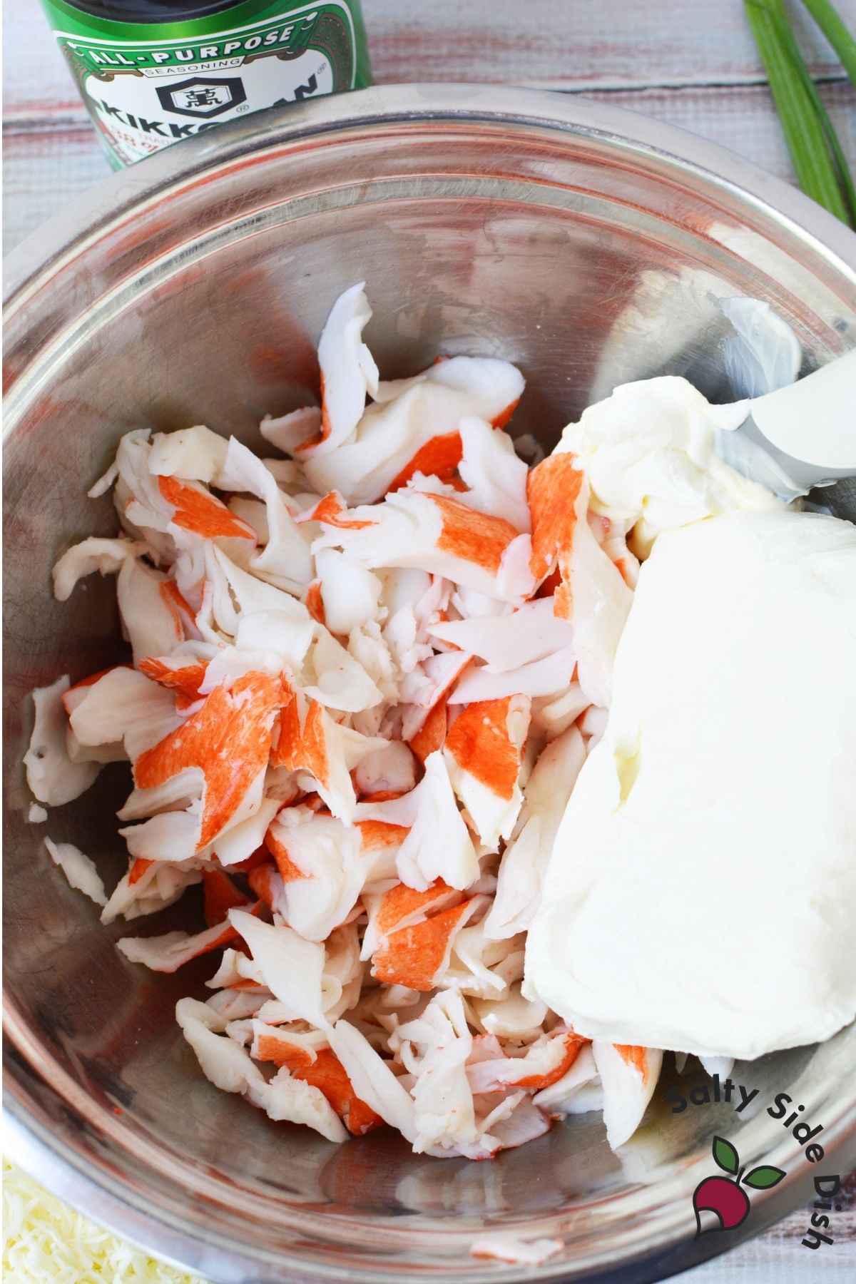 Imitation crab meat and cream cheese in a mixing bowl with soy sauce