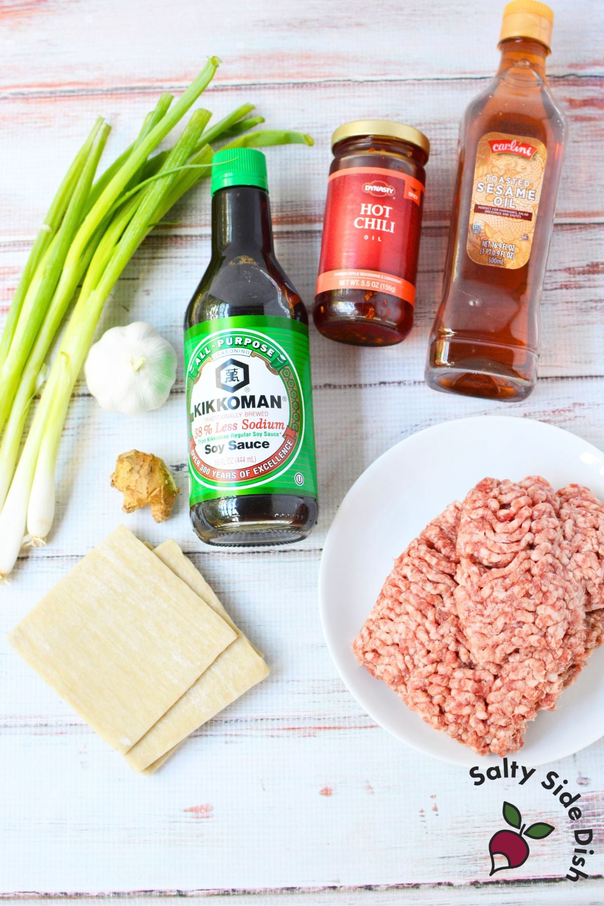 Ingredients for dumpling lasagna, including ground pork, wonton wrappers, green onions, garlic, ginger, soy sauce, chili oil, and sesame oil.