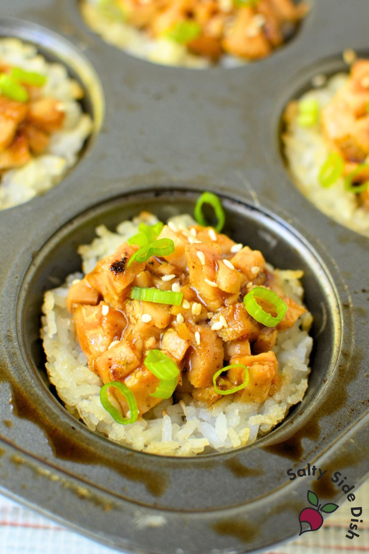 Chicken teriyaki rice cups arranged on a wood cutting board