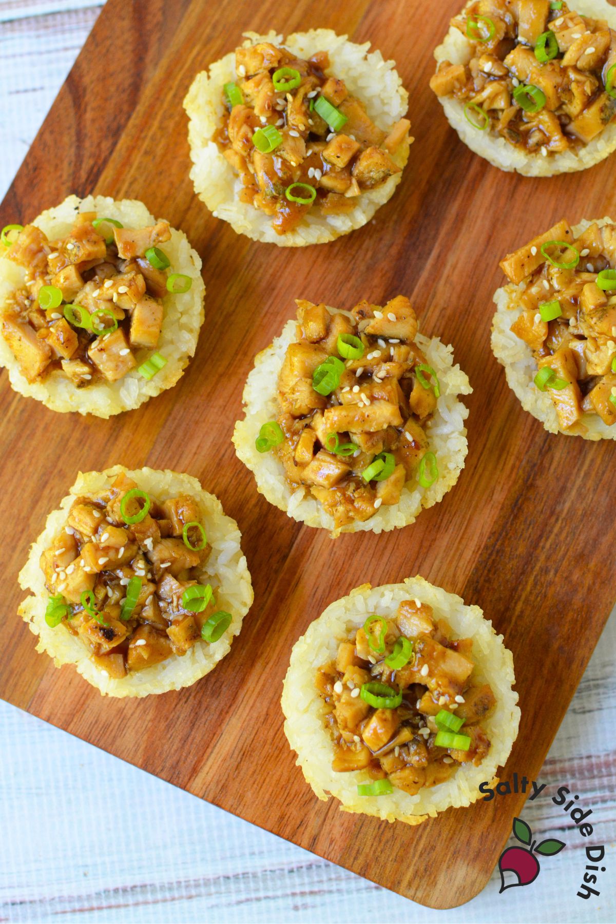 Rice cup topped with teriyaki chicken and sesame seeds in a muffin tin