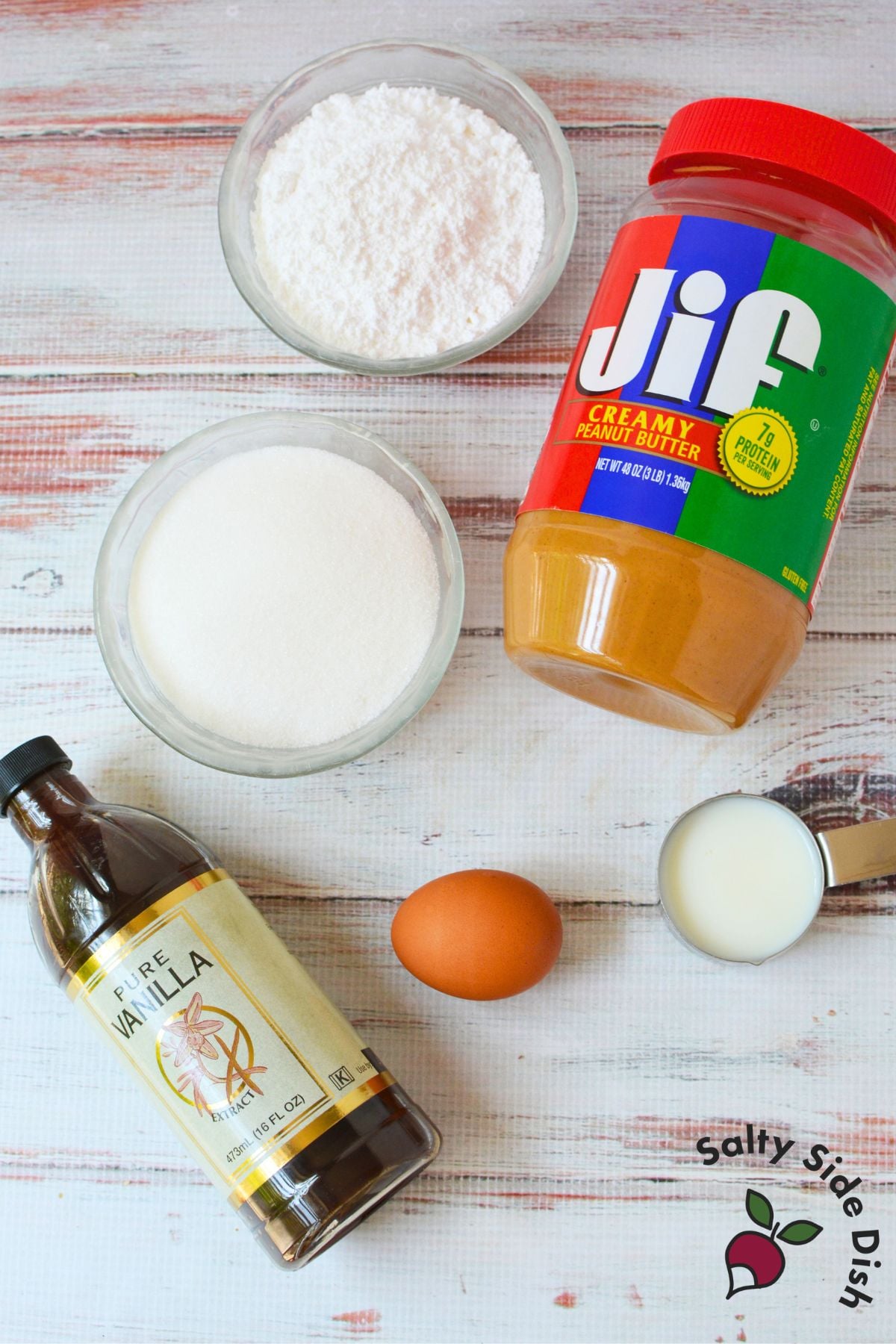 Ingredients for homemade Nutter Butter cookies including powdered sugar, granulated sugar, peanut butter, vanilla, egg and milk