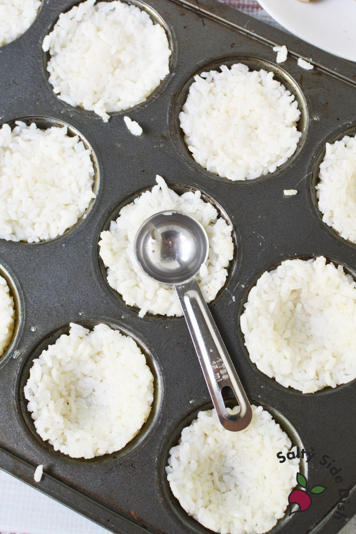 Rice pressed into a muffin tin with a portion scoop
