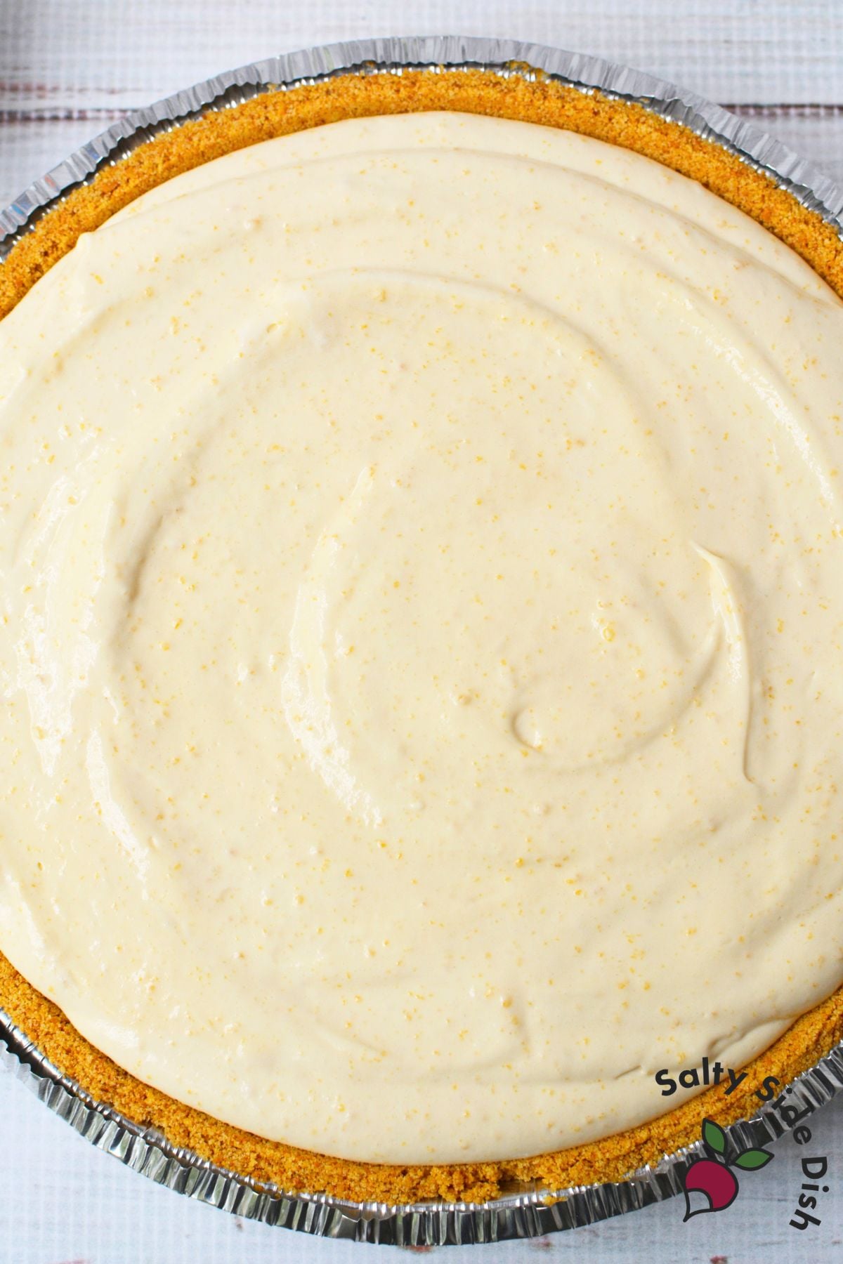 Root beer float pie filling spread into a graham cracker crust